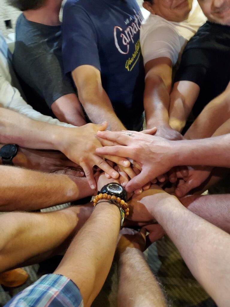 Men in a Circle stacking hands